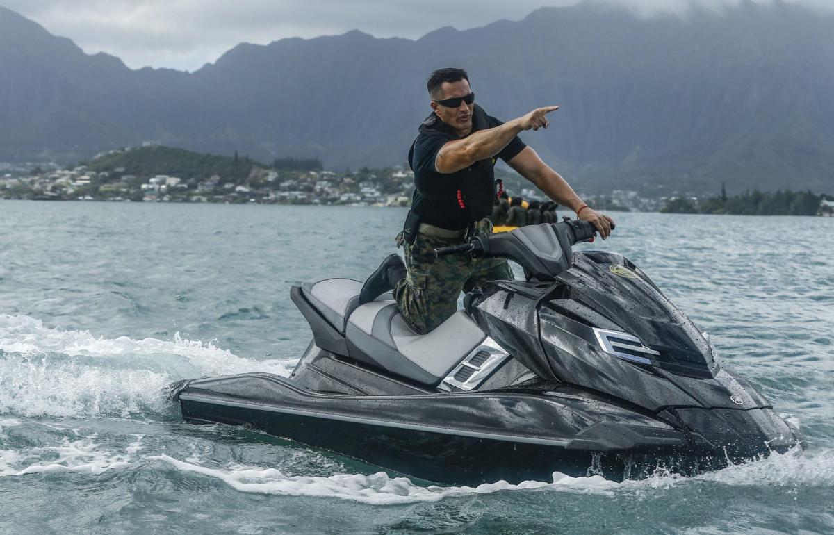 Marine gunnery sergeant directs his Marines from a jetski during a water rescue training event off the shore of Marine Corps Base Hawaii