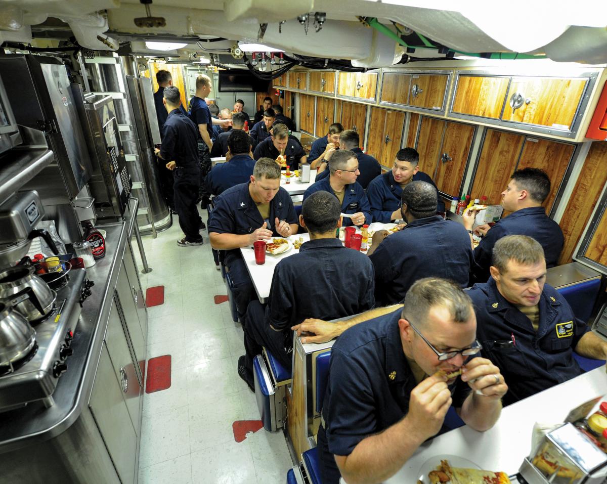 Sailors assigned to the Virginia-class fast attack submarine USS Indiana (SSN-89) eat dinner in the crew’s mess while under way