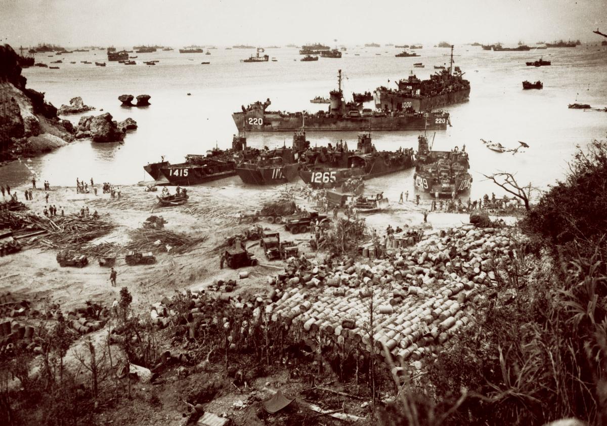 With ships out to the horizon as far as the eye can see, landing craft of the massive U.S. invasion armada pour out supplies and military equipment onto the beach at Okinawa in April 1945. From late 1944 into 1945, U.S. naval forces unleashed a “dazzling display of maritime power” while advancing toward Japan “with hardly a pause and without an important defeat.”