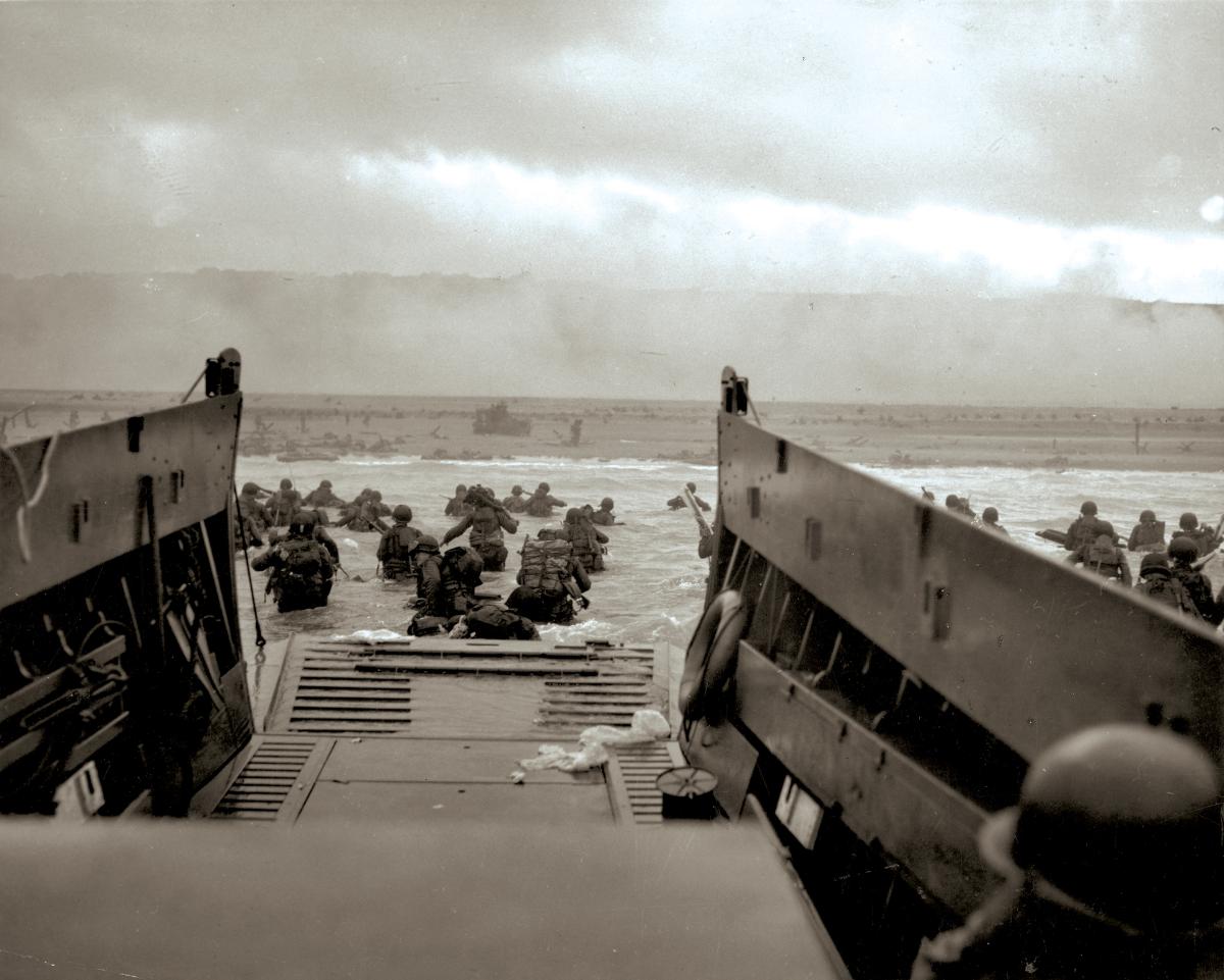 During Operation Neptune, GIs wade ashore on Normandy’s Omaha Beach.