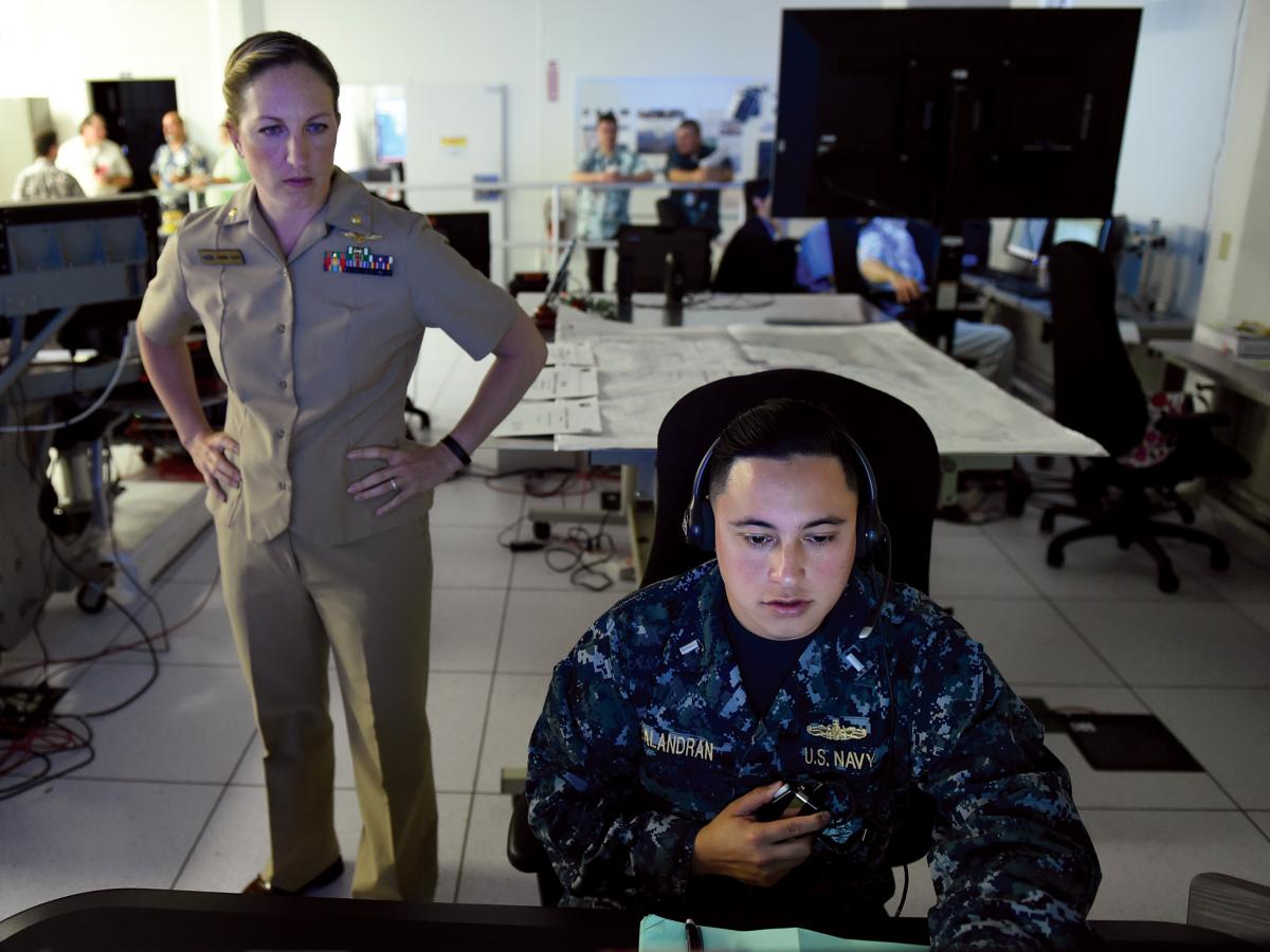 A Navy Reserve lieutenant commander from the Office of Naval Research (ONR) Reserve Component observes a junior surface warfare officer from Destroyer Squadron 31 call out contacts during an ONR demonstration of improved training that combines software and gaming technology. Navy active-duty commands should work closely with their Reserve components to ensure the best support.