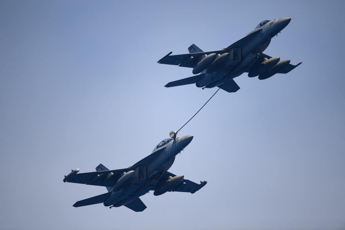 An F/A-18 Super Hornet assigned to Strike Fighter Attack Squadron 113 refuels an EA-18G Growler assigned to Electronic Attack Squadron 139