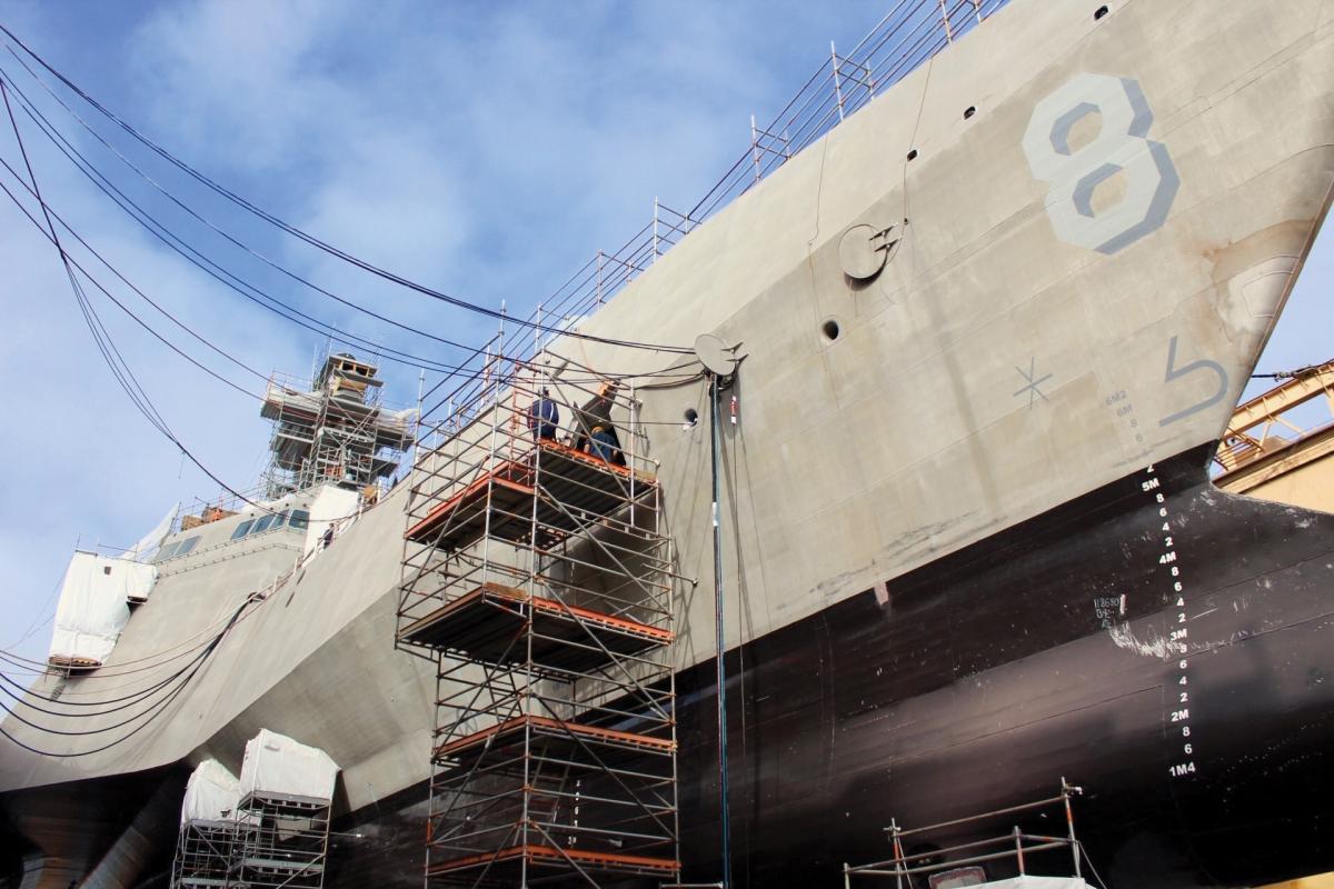 Shipyard workers in San Diego, California, perform upgrades on the forward mooring station of the littoral combat ship USS Montgomery (LCS-8).