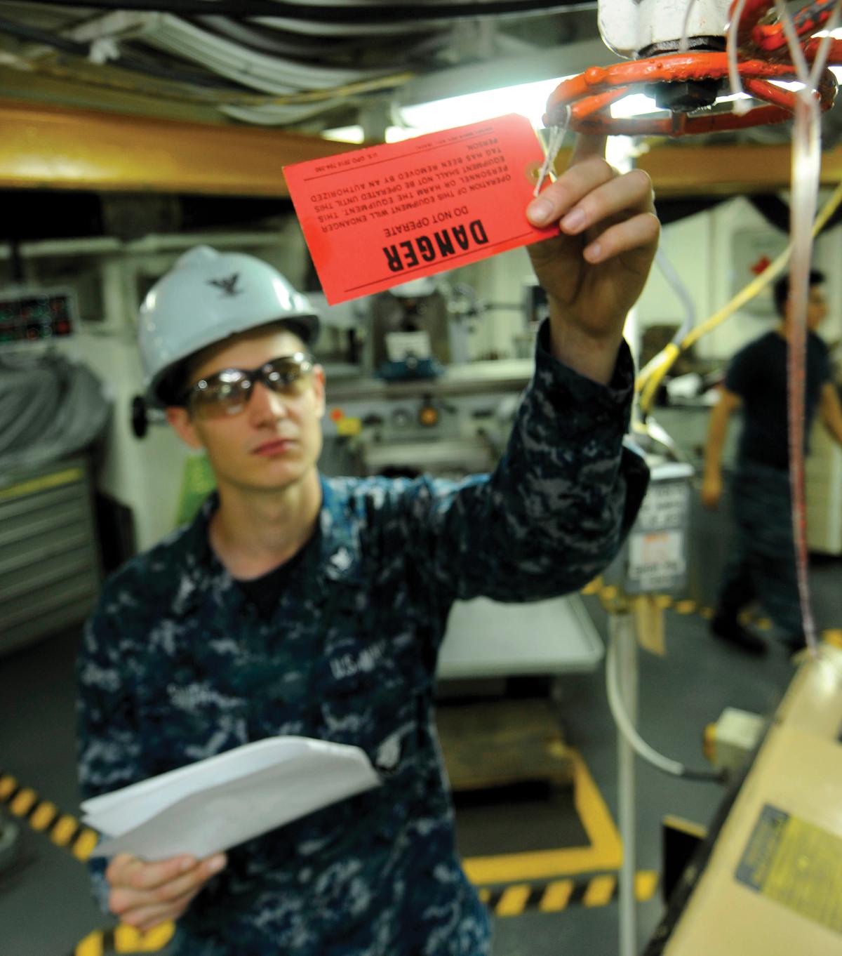 A machinist mate third class conducts a tagout audit.