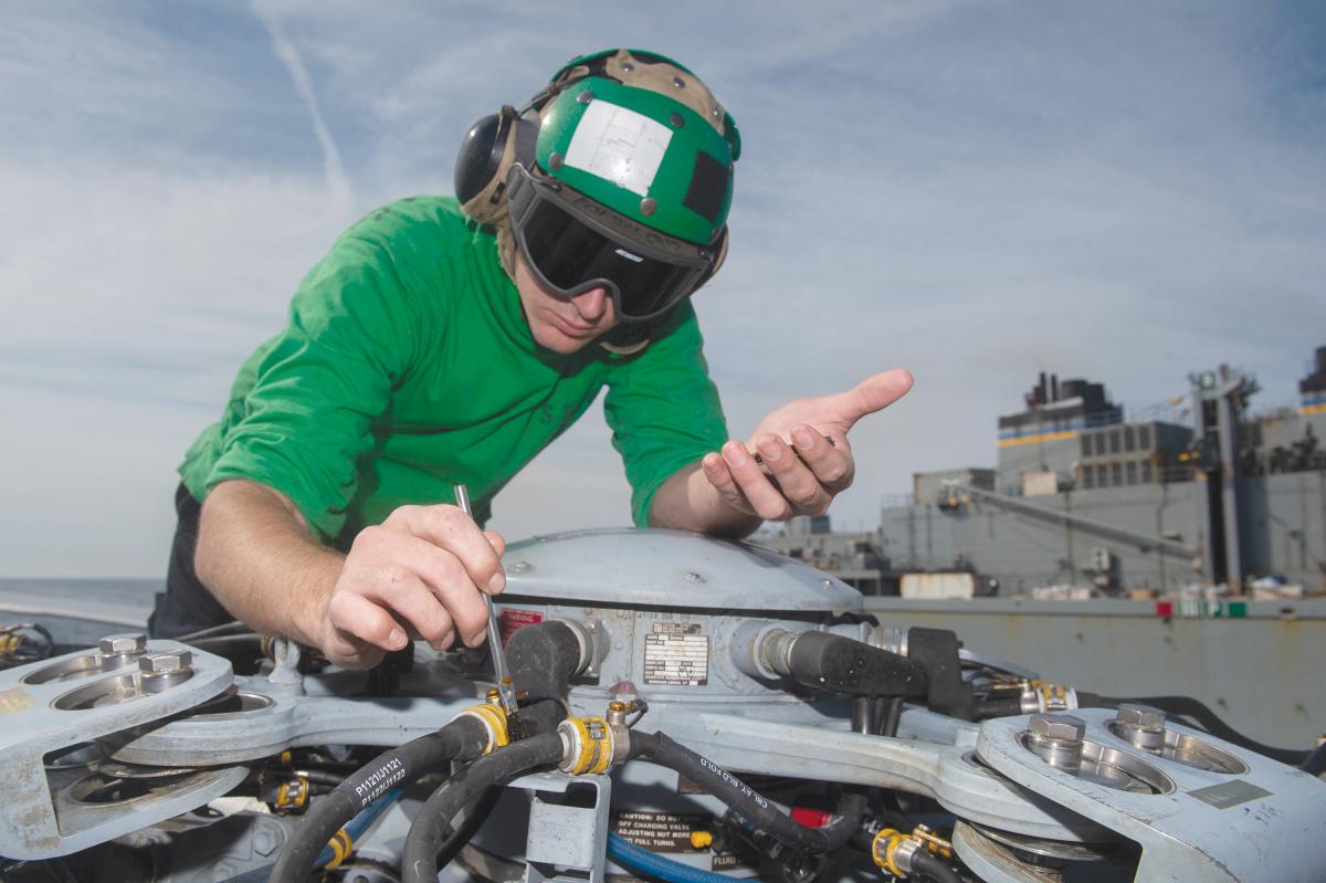 Aviation Electrician’s Mate Third Class Howard Weld conducts maintenance on an MH-60R Sea Hawk helicopter