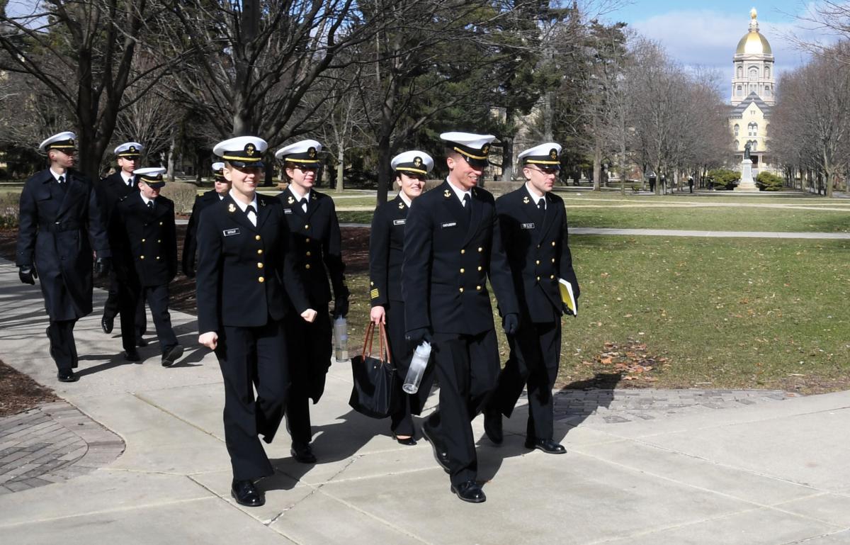 Naval Reserve Officers Training Corps (NROTC) midshipmen walk across the campus of the University of Notre Dame and past the iconic golden dome of the Basilica of the Sacred Heart