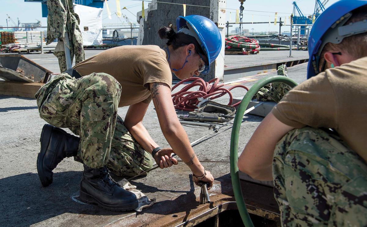 A USS George H. W. Bush (CVN-77) sailor performs corrosive control maintenance on board the ship in Norfolk Naval Shipyard in 2019. Long maintenance availabilities in shipyards are critical to the overall mission of the Navy, but present unique leadership challenges for the ship’s officers and chief petty officers.