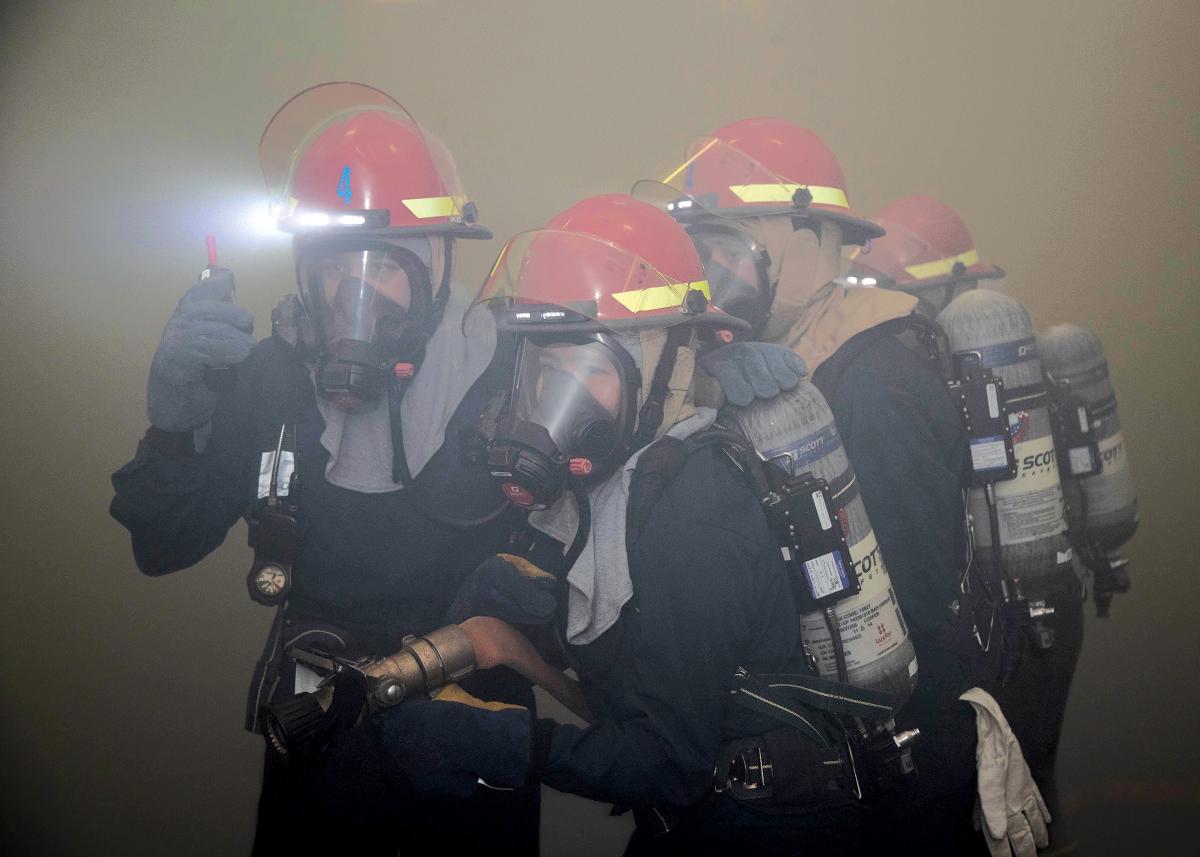 Sailors assigned to the USS Gerald R. Ford (CVN-78) respond to a simulated fire in the hangar bay. Because Navy sailors are responsible for fighting ships, rather than just operating them, a merchant mariner crew-rest standard should not be completely adopted.