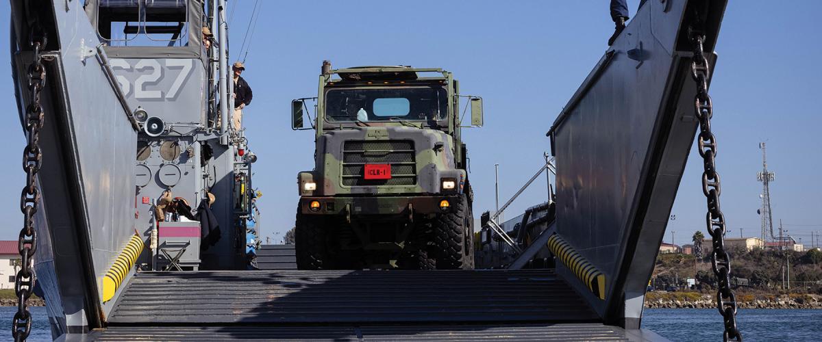 By working closely together, logisticians and intelligence personnel can determine the key adversary logistics nodes to attack and the U.S. logistics signatures to hide. Here,  U.S. Marines with Combat Logistics Regiment 1, 1st Marine Logistics Group offload a 7-ton truck from a landing craft, utility at Marine Corps Base Camp Pendleton, California. 