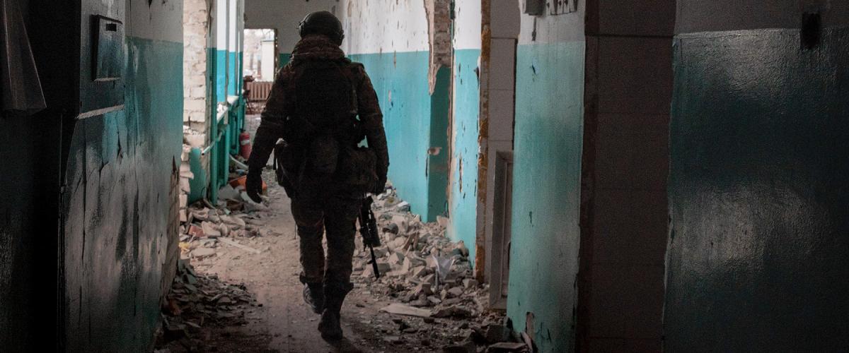 A Ukrainian soldier walks through a bombed-out school in Lyman, Ukraine, in January 2023. 