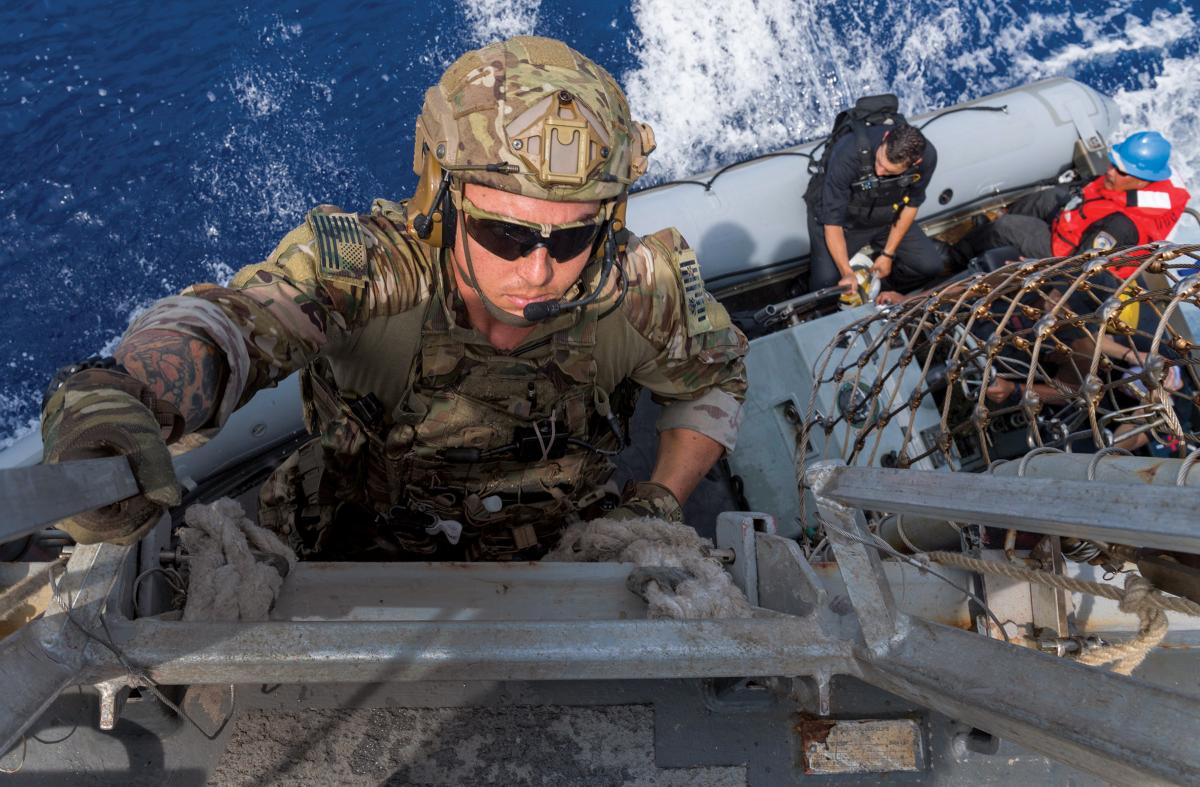 Coast Guard law enforcement detachments (LEDets) deploy with U.S. Navy strike groups as part of the Oceania Maritime Security Initiative. Here, a LEDet member climbs down to a rigid-hull inflatable boat to conduct a boarding mission.