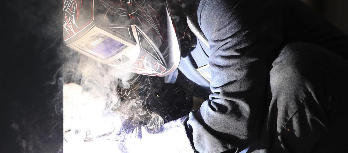 A hull maintenance technician works on the USS Tripoli (LHA-7). The United States must consider new strategies to address shipbuilding capacity. 