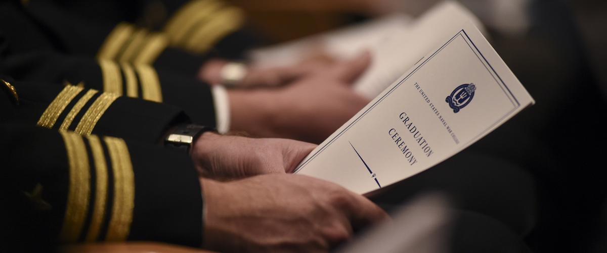 A U.S. Naval War College (NWC) student holds a program during his graduation ceremony held at NWC’s Spruance Auditorium. PME should be structured to promote warfare-focused intellectual skills.  