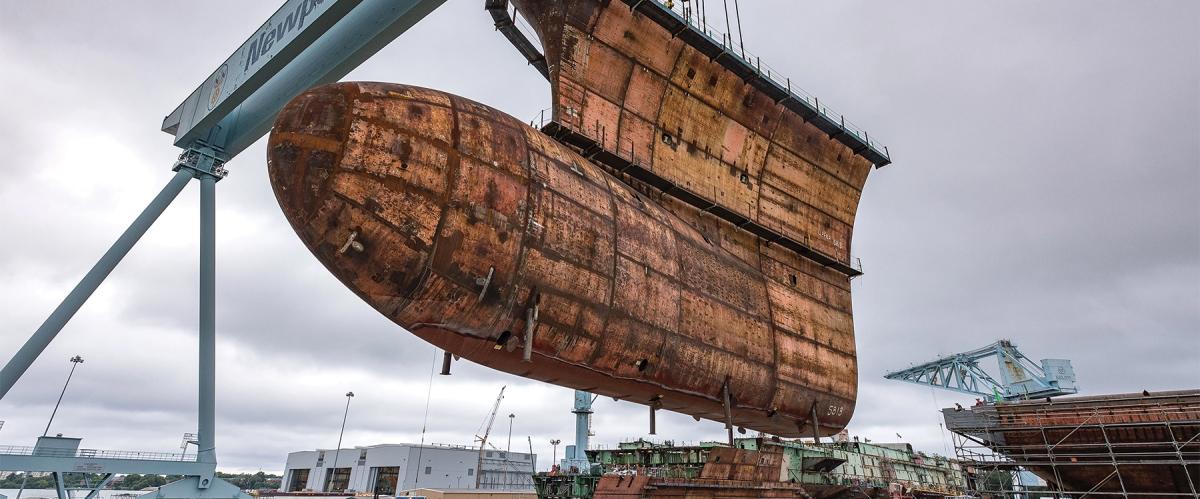 The final piece of the underwater hull of the aircraft carrier USS John F. Kennedy (CVN-79) being lowered into place in September 2019. The Navy needs to recapitalize the shipbuilding industry to produce the new capabilities and warships required to win the next war.