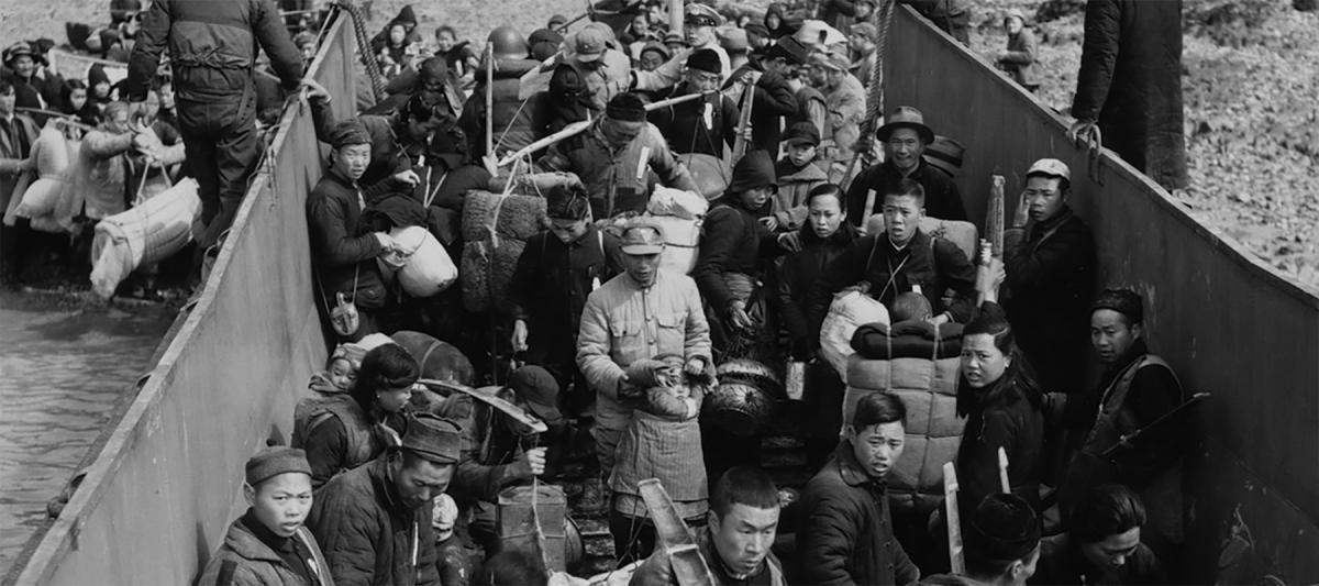 Civilians file aboard a U.S. Navy landing craft as thousands more jam the beaches awaiting evacuation to Taiwan, February 1955.