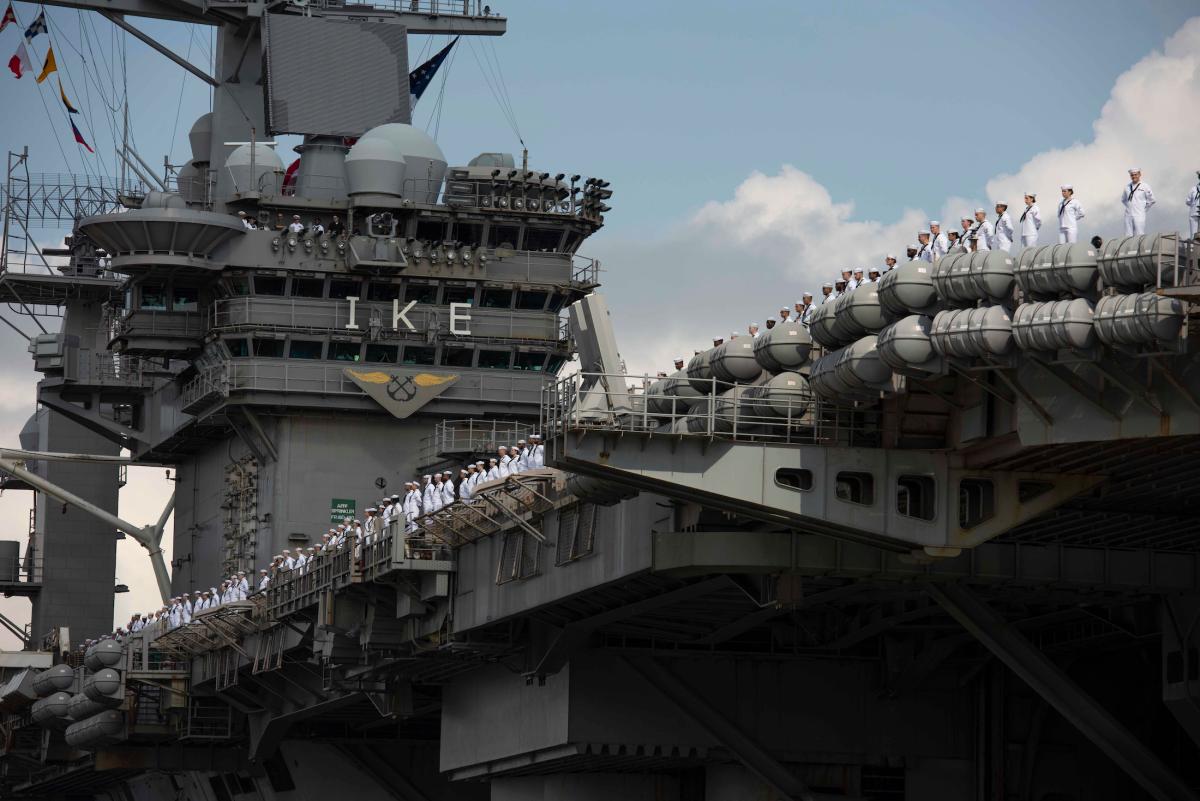 The crew of the USS Dwight D. Eisenhower (CVN-69) mans the rails as the carrier returns from a deployment in August.  