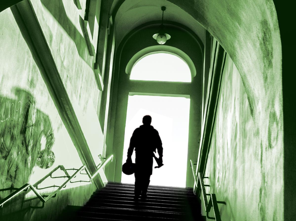 Pilot walking up stairwell into the light.