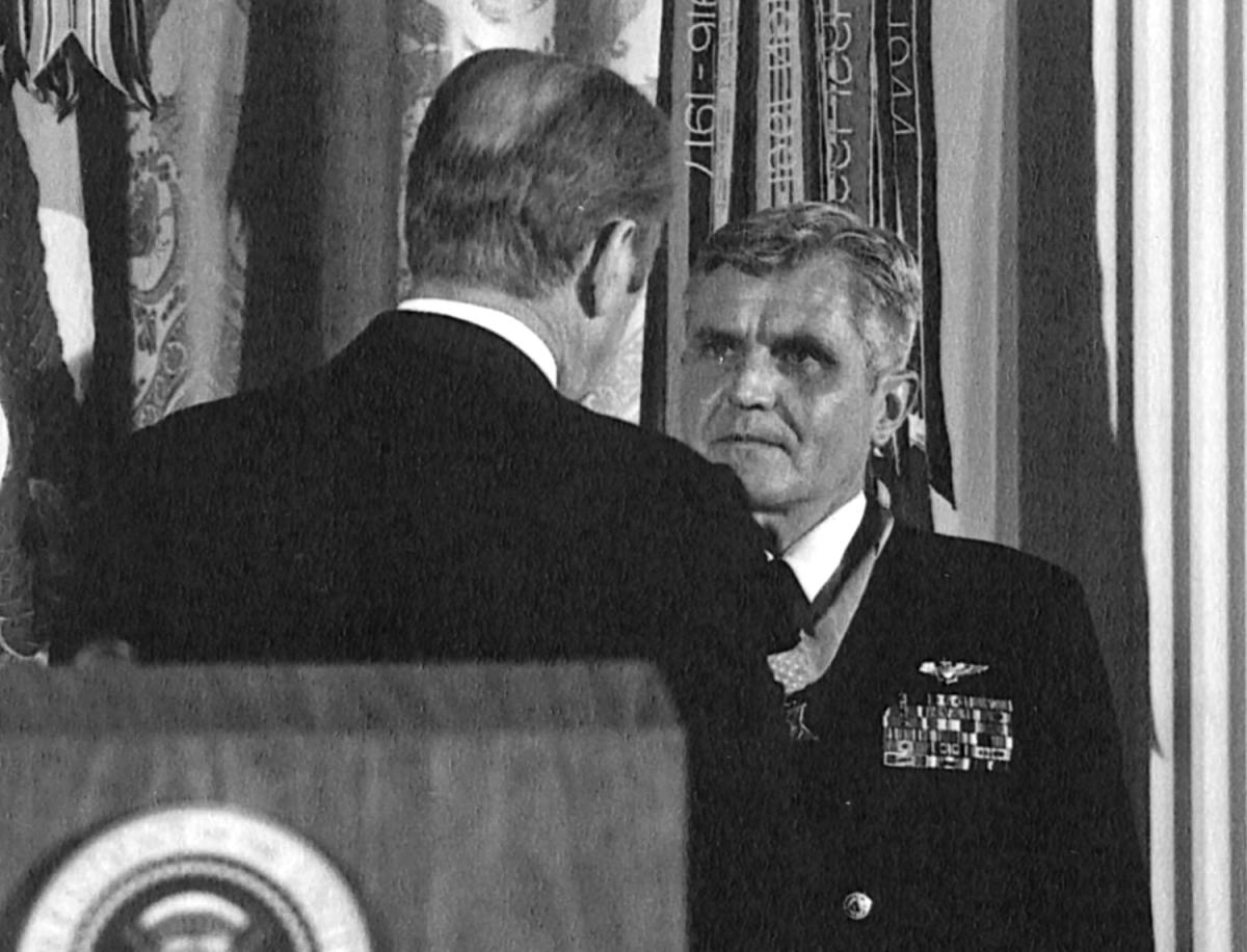 President of the United States of America, Gerald R. Ford, (back to camera) presents the Congressional Medal of Honor to Rear Admiral James B. Stockdale, USN, during an awards ceremony in the East Room of the White House