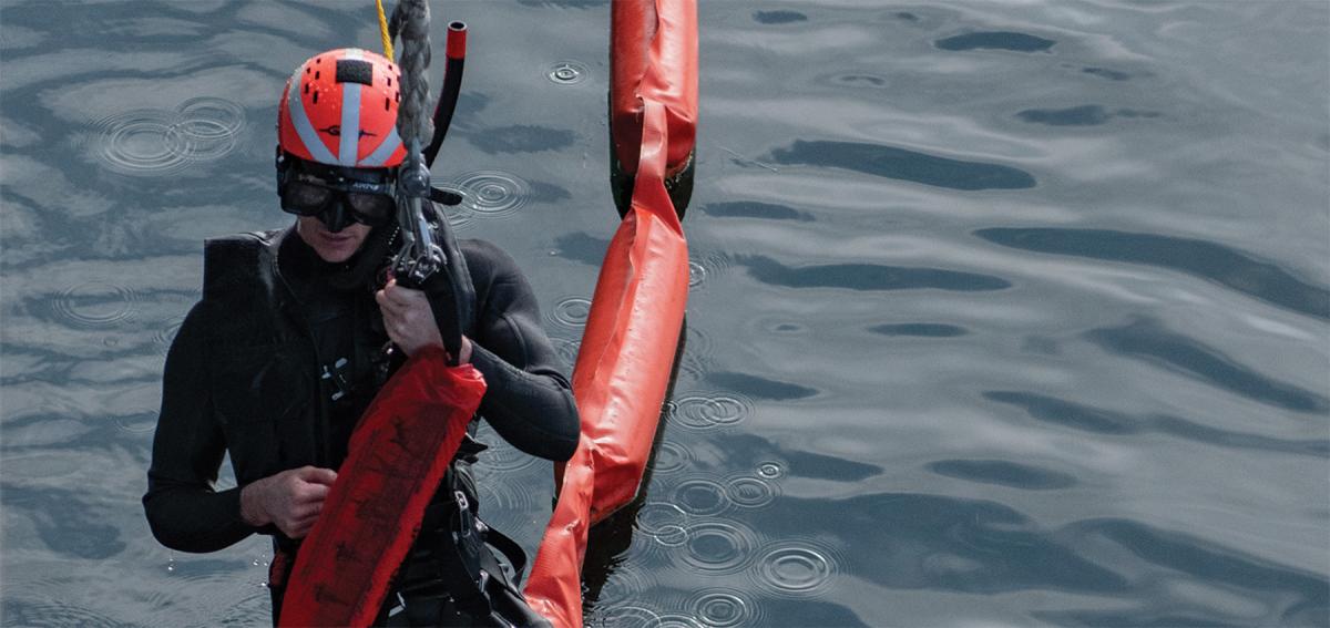 A search-and-rescue swimmer is raised onto the USS Chosin (CG-65). Some personnel redlines include a requirement for two rescue swimmers, without which ships may be unable to sail without flag approval.