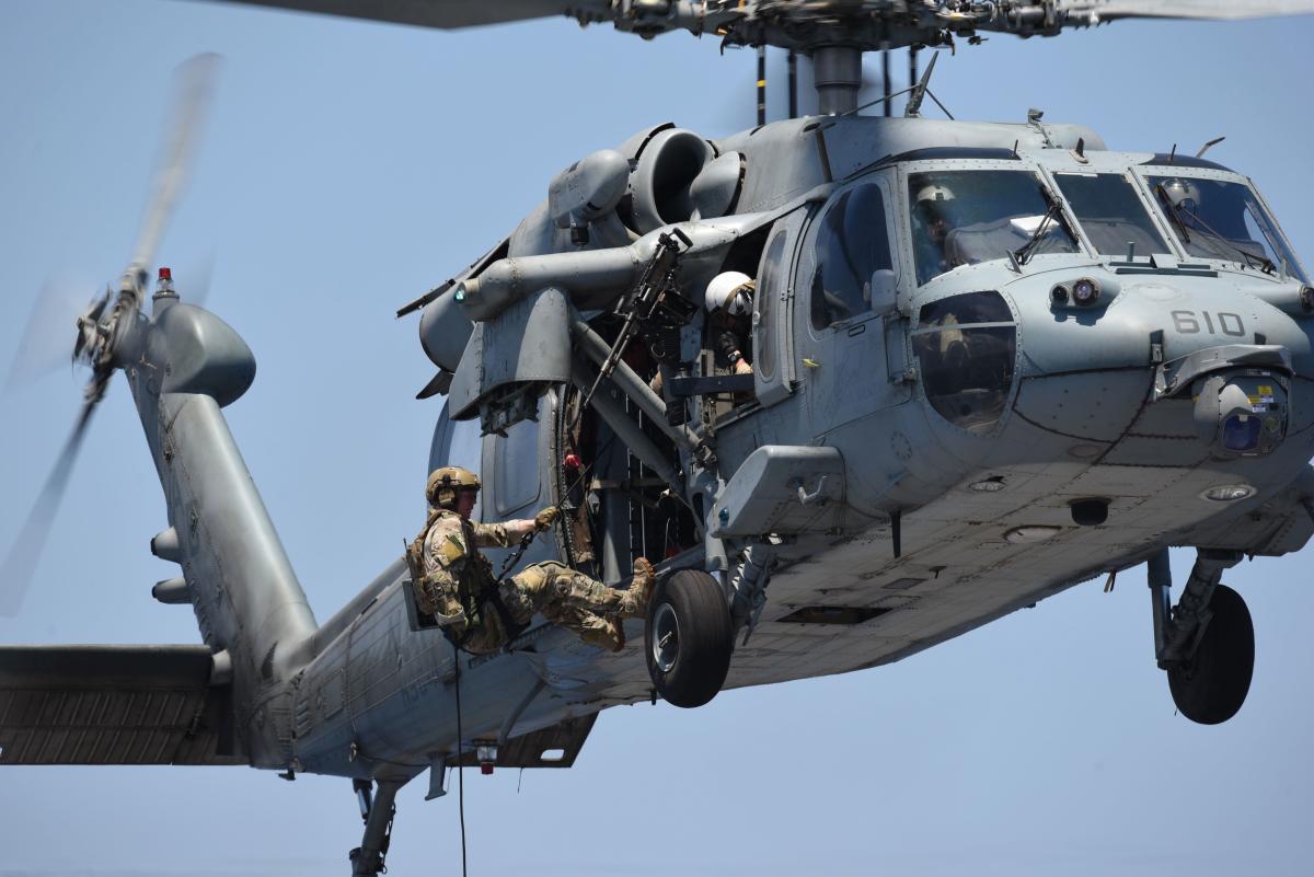  Lt. Braden Schrock prepares to fast-rope from an MH-60S Seahawk helicopter, assigned to the "Dragon Slayers" of Helicopter Sea Combat Squadron (HSC) 11, on to the flight deck aboard the Nimitz-class aircraft carrier USS Harry S. Truman (CVN-75)