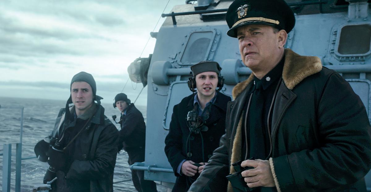 Commander Ernest Krause, portrayed by  Tom Hanks, looks seaward from the flying bridge of the fictional destroyer USS Keeling, in a scene from Greyhound. Krause has the arduous task of protecting an Allied convoy during a running battle with a U-boat wolf pack. 