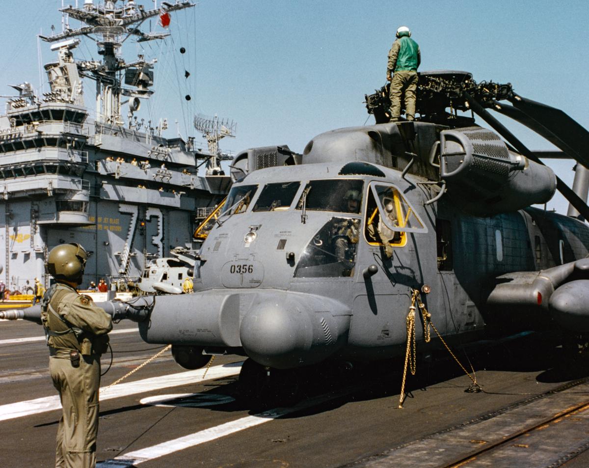 Crewmembers from the 20th Special Operations Squadron complete tiedown of their MH-53 on the flight deck of the USS George Washington CVN 73 during joint operation exercises