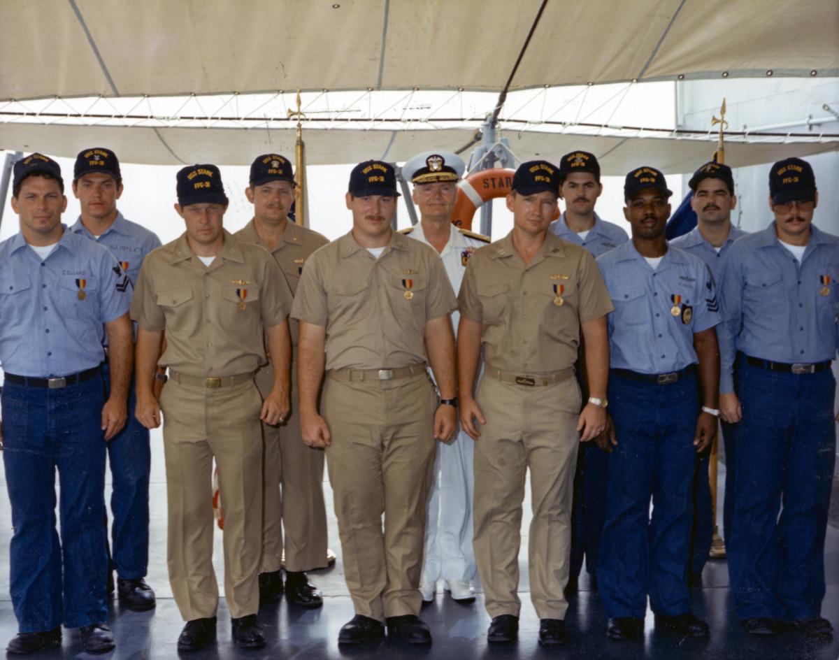 en crew members of the USS Stark (FFG-31) pose for a group photo after receiving the Navy and Marine Corps Medal for heroism.
