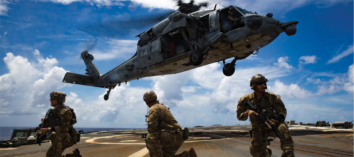 Sailors from Explosive Ordnance Disposal Mobile Unit 3 practice helicopter visit, board, search, and seizure activities. During war, enemy-flagged civilian ships and contraband-carrying neutral vessels—as distinguished from enemy warships or neutral ships engaged in hostilities—can lawfully be seized and disposed of through a formal legal process under prize law.