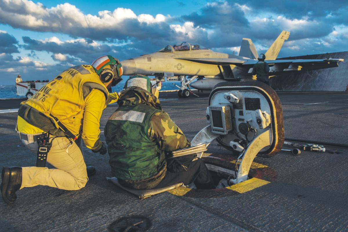 Sailors aboard the aircraft carrier USS Ronald Reagan (CVN 76) monitor the pitch of the ship prior to launching an  F/A-18F Super Horne