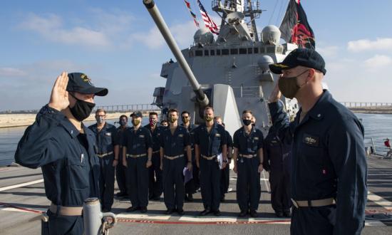 The commanding officer of the USS Sterett (DDG-104) administers the oath of office to an ensign during his promotion to lieutenant (j.g.).