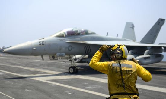 Aviation Boatswain's mate directs an EA-18G Growler, from the “Gray Wolves” of Electronic Attack Squadron (VAQ) 142, on the flight deck of the aircraft carrier USS Nimitz (CVN 68), July 25, 201
