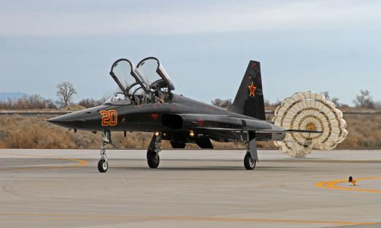  An F-5 Tiger II, attached to the "Saints" of Fighter Squadron Composite (VFC) 13, taxis after deploying a drag parachute upon landing on Naval Air Station Fallon