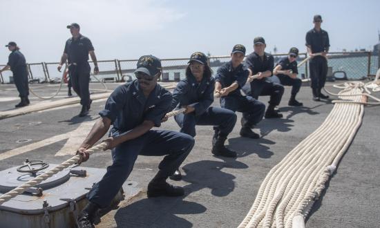 Sailors pulling a line.