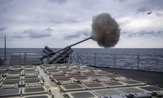 The Ticonderoga-class guided-missile cruiser USS Normandy (CG-60) fires its aft Mark 45 mod 4 5-inch gun during a live-fire exercise in the Mediterranean Sea. Cells from the ship’s Mk 41 vertical launching system are visible in the foreground.