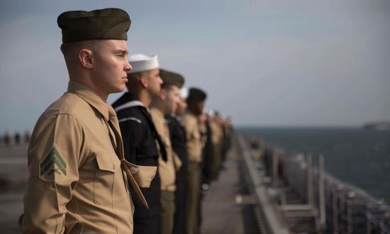 Sailors and Marines assigned to the 24th Marine Expeditionary Unit (24th MEU) man the rails of the amphibious assault ship USS Bataan (LHD 5).