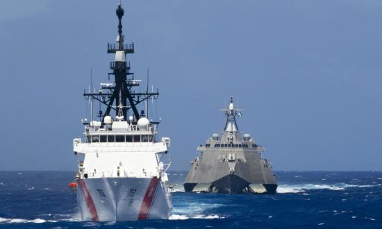 A U.S. Coast Guard Cutter sails with a Navy littoral combat ship.