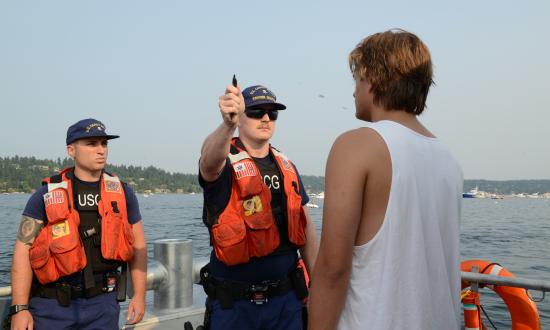 Petty Officer 2nd Drew Allen and Petty Officer 2nd Class Jordan Kuehl perform field sobriety tests on a boater during Seattle’s Seafair, 5 August 2017. 