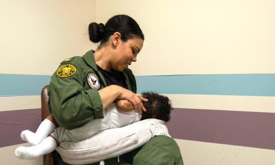 A sailor nurses her child