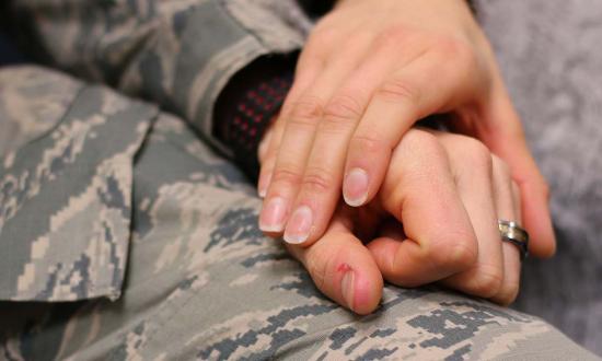 A service member and their spouse holding hands. 