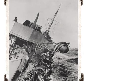 A U.S. Navy destroyer escorts a United Nations convoy somewhere in the North Atlantic on 30 June 1943. A heavy roll in rough seas.