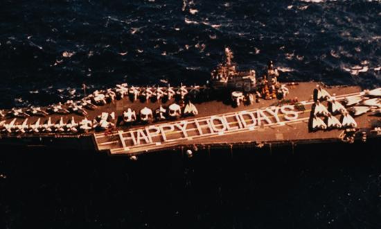 Nearly 2,000 sailors from the USS Kitty Hawk (CV-63) and Carrier Air Wing 15 wish the United States a “Happy Holidays” at the conclusion of their six-month western Pacific deployment on 14 December 1994.