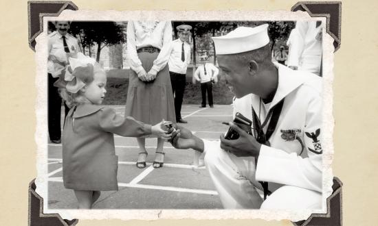 BM3 Demetrius A. Haughbrook offers a piece of candy to  a young resident of Vladivostok, Russia. Sailors and citizens of the area frequently exchanged small gifts during the four-day port visit in 1990. (Jim McGee)