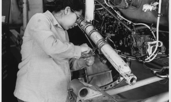 A technician works on an engine. 1980s photographer PH3 Charles Ervin.