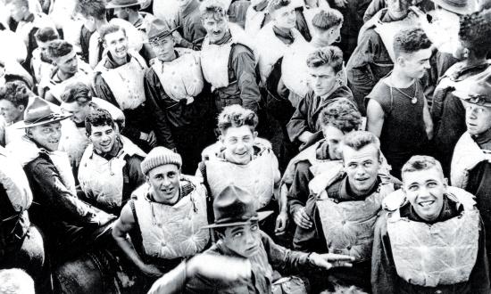 Troops in life jackets crowd the main deck of the USS President Lincoln as she steams through the submarine “danger zone” in the Atlantic on 25 December 1917.