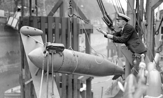 A paravane is being affixed to the side of HMS President, 26 August 1937. Royal Navy Commander C. D. Burney initially conceived of paravanes as antisubmarine systems, but they became most useful for minesweeping.