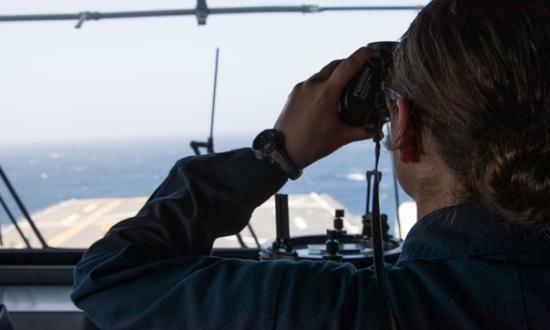 A woman looking through binoculars. 