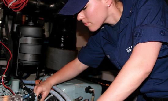 A machinery technician stationed at Coast Guard Station Cape May, New Jersey, works on an engine on board a  47-foot motor lifeboat. 