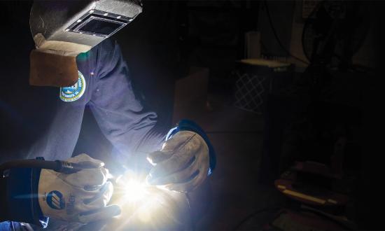 A welding shop work leader works on a mockup at Norfolk Naval Shipyard.