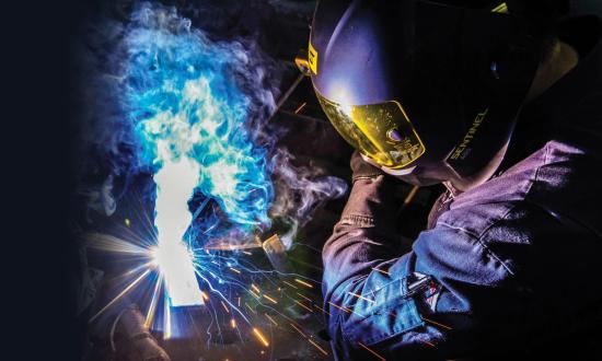 Hull Technician 3rd Class Jose Rodriguez welding L-brackets together inside a workshop