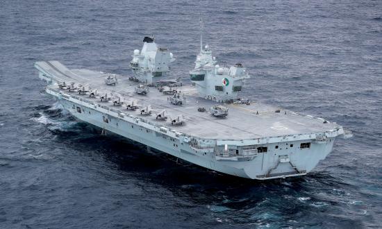 HMS Queen Elizabeth under way during training exercises in October 2020.  A dozen F-35B strike fighters  and four Merlin  naval helicopters  are visible on the flight deck.